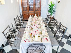 a long table in a room with roses on the table at Riad Sifaw & Spa Marrakech in Marrakech