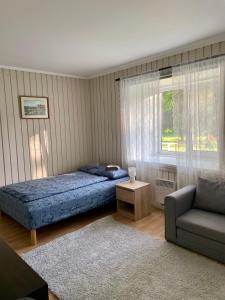 a bedroom with a bed and a couch and a window at Tooraku Turismitalu in Pusku