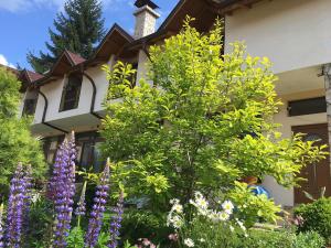 um jardim em frente a uma casa com flores em Guesthouse Elizabeth em Samokov