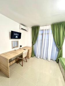 a living room with a wooden desk and green curtains at Vila Sedef Costinești in Costinesti