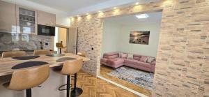 a living room with a table and a pink couch at Green bay apartment in Korčula