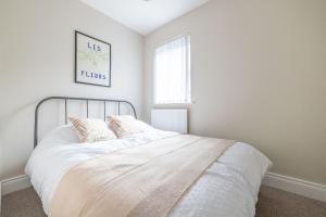 a bedroom with a bed with white sheets and a window at Hillview House in Belfast