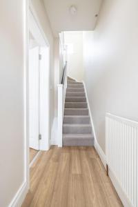 a staircase in a house with white walls and wooden floors at Hillview House in Belfast