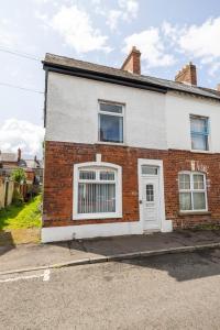 a red brick house with a white door at Hillview House in Belfast