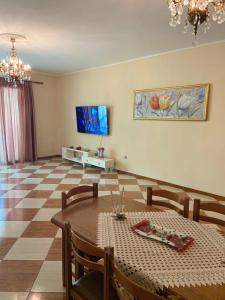 a living room with a table and a television at Family Comfort and Central Apartment in Vlora in Vlorë