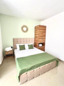 a bedroom with a large bed with a green blanket at Vila Sedef Costinești in Costinesti
