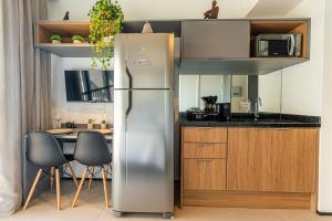 a kitchen with a stainless steel refrigerator and a table at LG1308 - Studio moderno | ao lado Metrô Santa Cruz in Sao Paulo