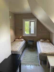 a small room with two beds and a window at Tooraku Turismitalu in Pusku +33 photos