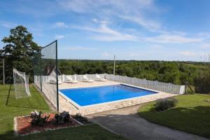 a pool with a volleyball net in a yard at Teo-Sport in Cerovac