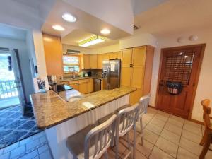 a kitchen with a counter and some chairs in it at Beach Blossum home in Saint Augustine