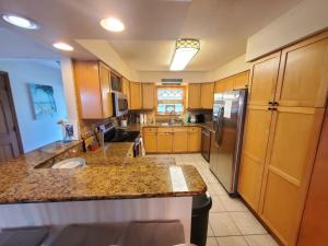 a kitchen with wooden cabinets and a stainless steel refrigerator at Beach Blossum home in Saint Augustine