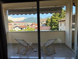 two chairs sitting on a balcony with a view at Casa Palmy in Verbania