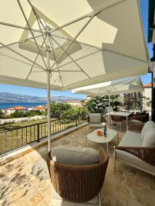 a patio with two chairs and an umbrella at House Bianca Brac - New Listing - Experienced host in Postira