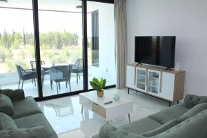 a living room with a couch and a tv and a table at Infinity Luxury Mansions in Yeri