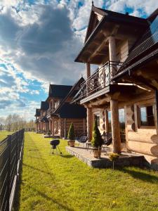 a log house with a balcony on the lawn at Domki Góralskie Anna Maria in Chochołów