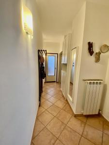 a hallway with white walls and a tile floor at Casa Blu di Pomposa Vista Mare in Lido di Pomposa
