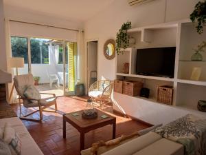a living room with a couch and a tv at Villa Blue - Aldeia do Golfe in Quarteira