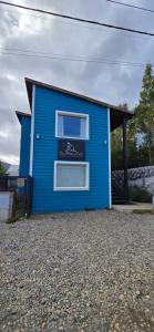a blue house with a sign on the side of it at Apart Guillaumet in El Chalten