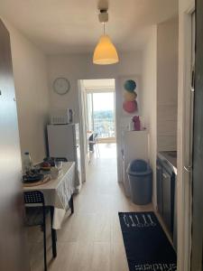 a room with a kitchen with a table and a refrigerator at En hauteur, au pied du métro & 7mn du centre Lille in Mons-en-Baroeul