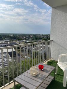 a table on a balcony with a view of a city at En hauteur, au pied du métro & 7mn du centre Lille in Mons-en-Baroeul +8 photos
