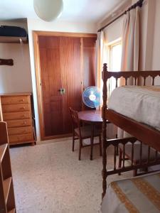 a bedroom with a bed and a desk and a table at Apartamento vistas al mar in Matalascañas