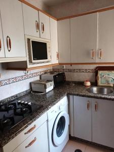 a kitchen with a washing machine and a sink at Apartamento vistas al mar in Matalascañas