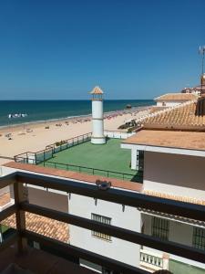 a tennis court on the beach with a lighthouse at Apartamento vistas al mar in Matalascañas