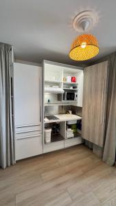 a kitchen with a white refrigerator and a table at L'Escale - vue mer avec cuve in Saint-François
