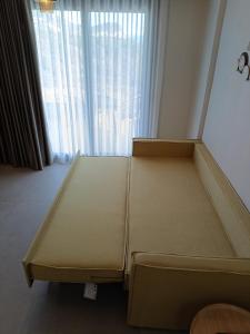 a bed in a room with a large window at GeoMar Luxury Apartments in Skala Marion