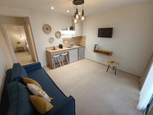 a living room with a blue couch and a kitchen at GeoMar Luxury Apartments in Skala Marion