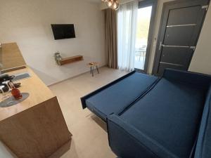 a room with a blue bed and a kitchen at GeoMar Luxury Apartments in Skala Marion