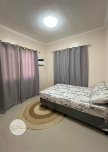 Ce lit se trouve dans un dortoir doté de rideaux et d'un tapis. dans l'établissement Cozy Home, à Dipolog 22 autres photos