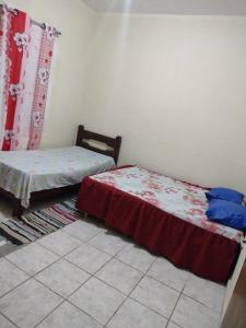 une chambre avec deux lits dans une pièce dans l'établissement Cantinho da Fla, à Itanhaém