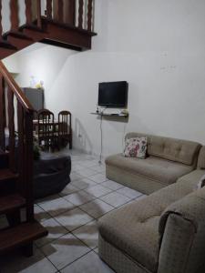 un salon avec un canapé et une télévision dans l'établissement Cantinho da Fla, à Itanhaém