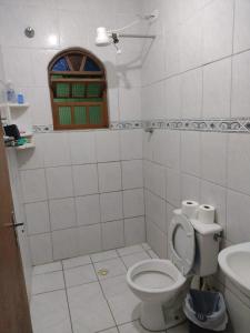 une salle de bain avec toilettes, lavabo et fenêtre dans l'établissement Cantinho da Fla, à Itanhaém 11 autres photos
