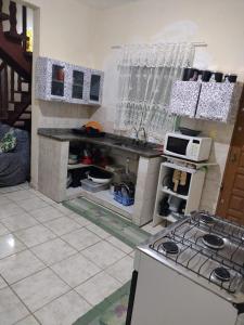 une cuisine avec une cuisinière et un comptoir dans l'établissement Cantinho da Fla, à Itanhaém