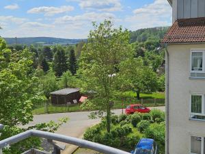 Una vista desde un balcón de una casa con un coche rojo. en Karls Apartment B09, en Gera