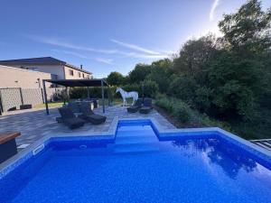 a swimming pool with chairs and a horse in a yard at Ferienwohnungen Nalbach Bierbach Wohnung 2 in Nalbach