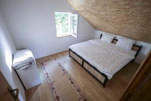a small bedroom with a bed and a window at Čemerno Mountain House in Gacko