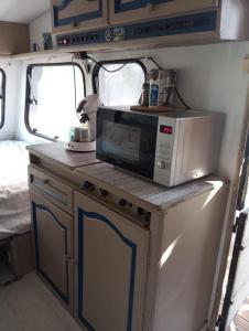 a microwave sitting on top of a kitchen in an rv at Caravane en pleine nature in Donnezac