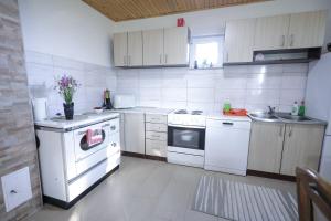 a kitchen with white appliances and white cabinets at Čemerno Mountain House in Gacko +18 photos