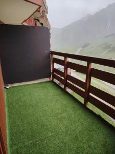 a balcony with green grass and a fence at Appart 4/6 pers pied des pistes La Mongie in Bagnères-de-Bigorre +9 photos