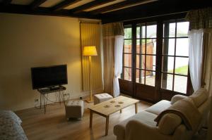 a living room with a couch and a tv at Juniper House in Vulaines-sur-Seine
