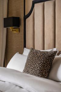a bed with a black headboard and a leopard print pillow at Hotel Experior Boutique - Destigo Hotels in Kraków