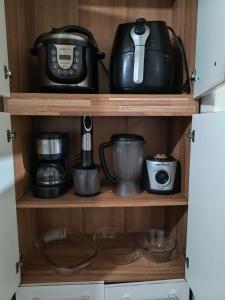 a shelf with pots and pans and a tea kettle at Flores da vovó in Campos do Jordão