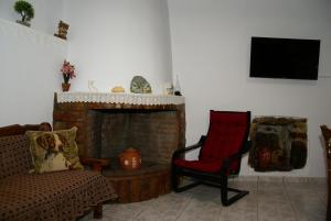 a living room with a chair and a fireplace at Socros Home, Mesta Chios in Mestá