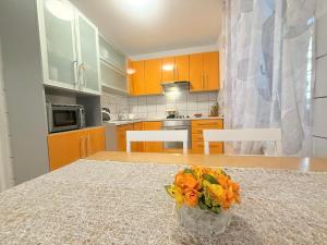 a kitchen with a table with a vase of flowers on it at House Rukavina in Bakarac