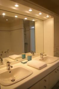 La salle de bains est pourvue de 2 lavabos et d'un grand miroir. dans l'établissement Juniper House, à Vulaines-sur-Seine