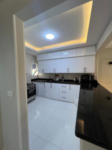 a kitchen with white cabinets and a white tile floor at Beach Villa in Ras Sidr at Red Sea in Ras Sedr