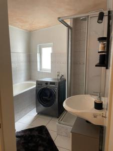 a bathroom with a washing machine and a sink at Ferienhaus Holiday Heaven in Schwarzatal +23 photos